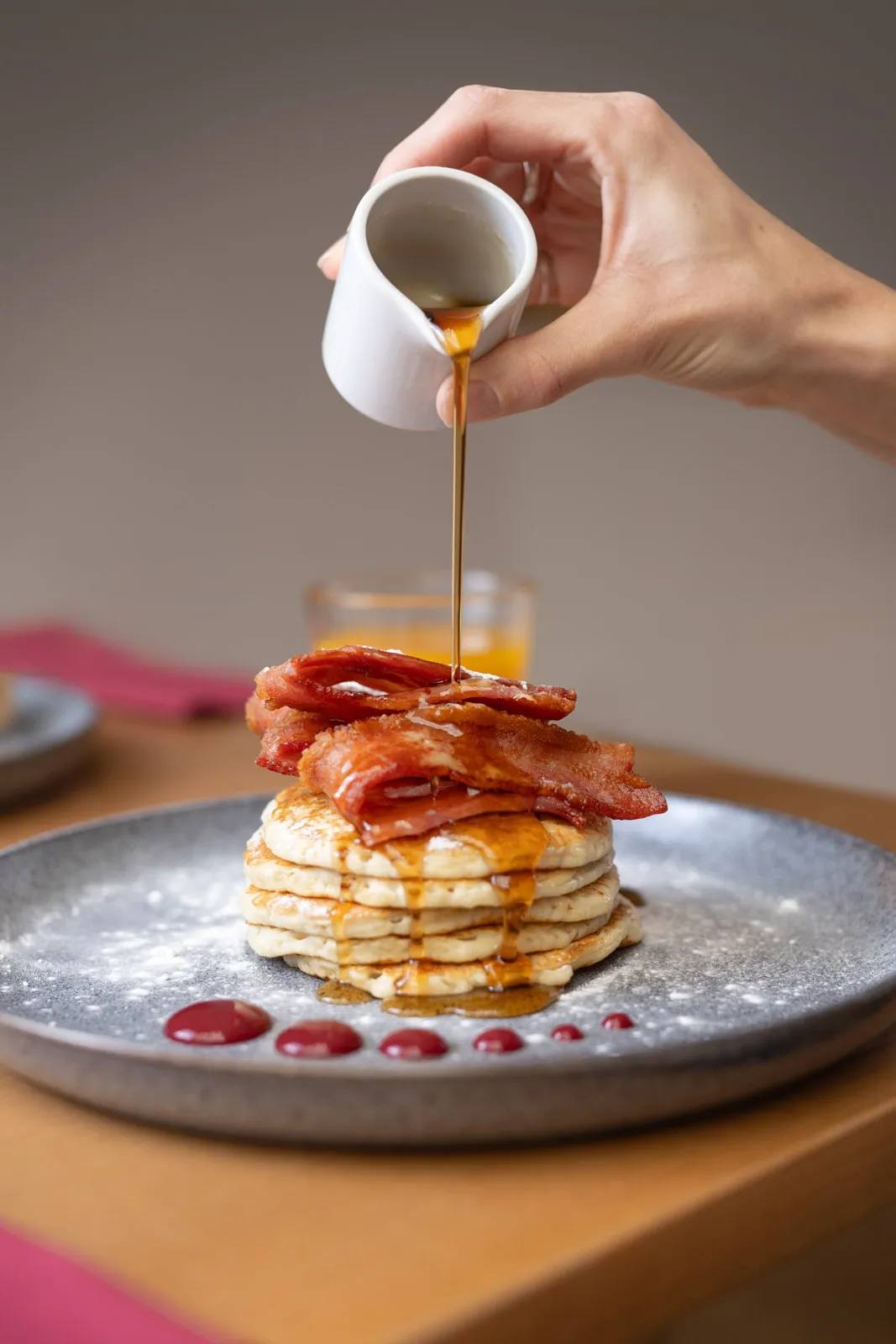 Maple syrup is poured over buttermilk pancakes
