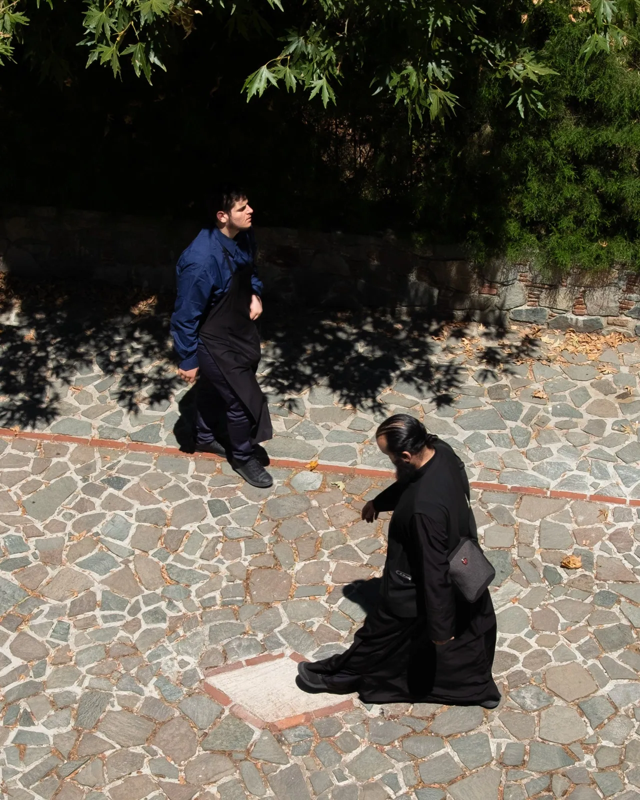 Two orthodox monks pass each other in a monastery in Cyprus
