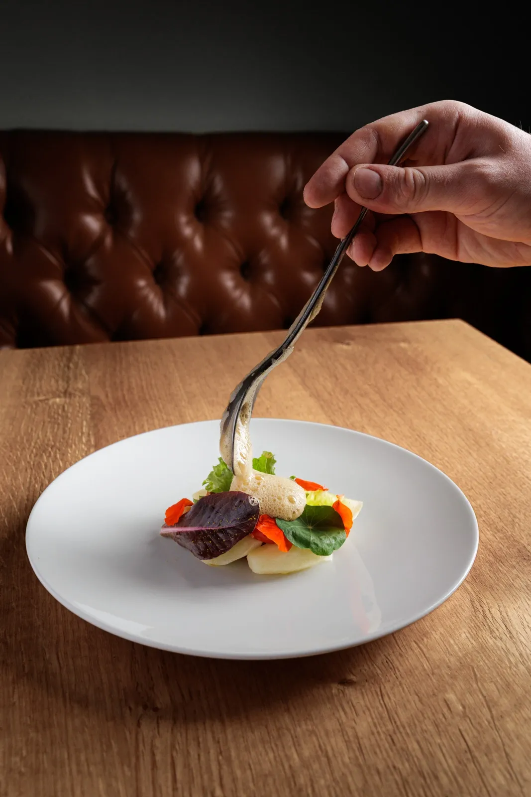 Chef Harrison Brockington spoons on Lobster bisque foam onto native lobste tail and new potatoes, fennel