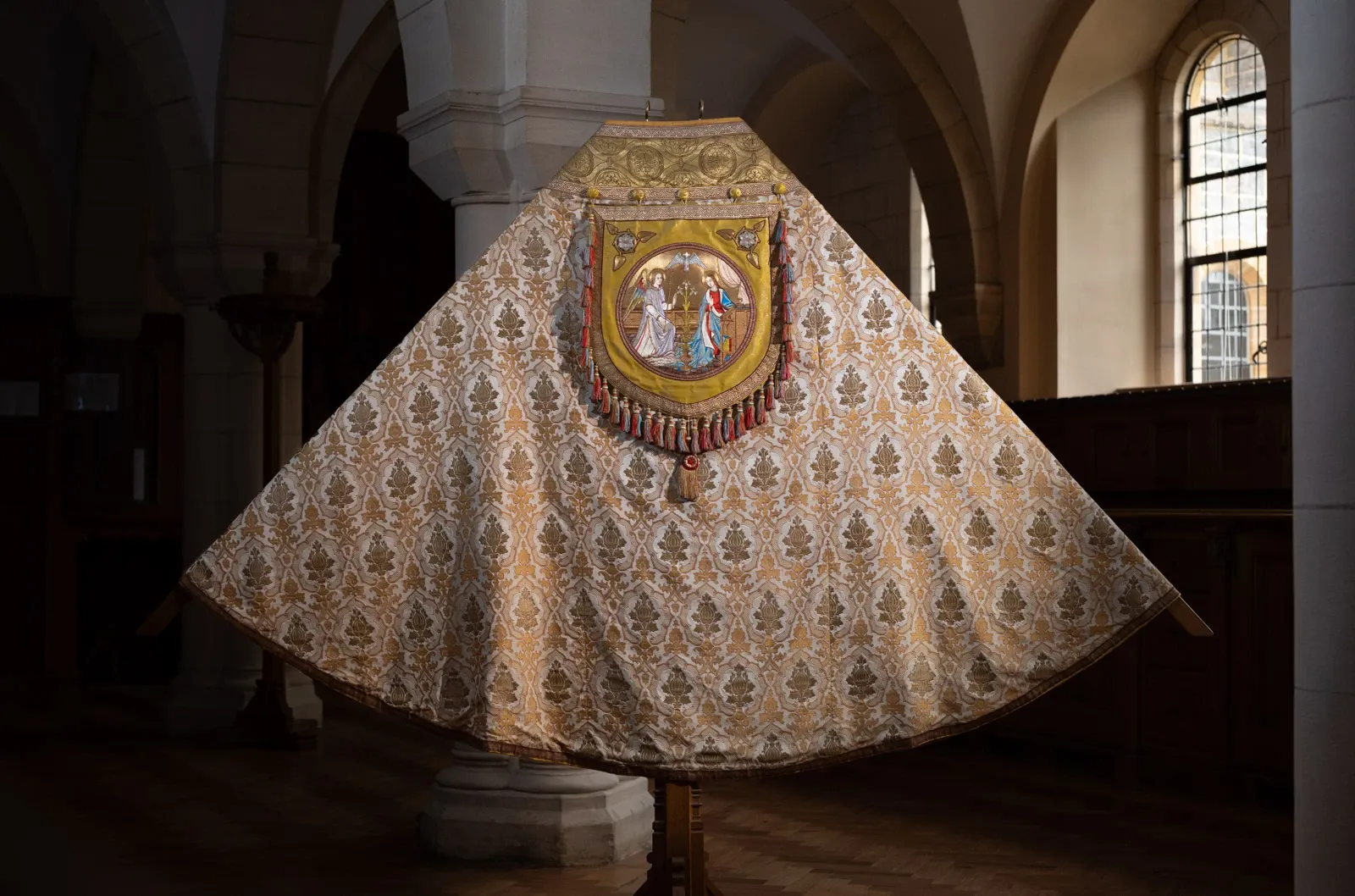 An exquisite cope is displayed depicting the annunciation on the back