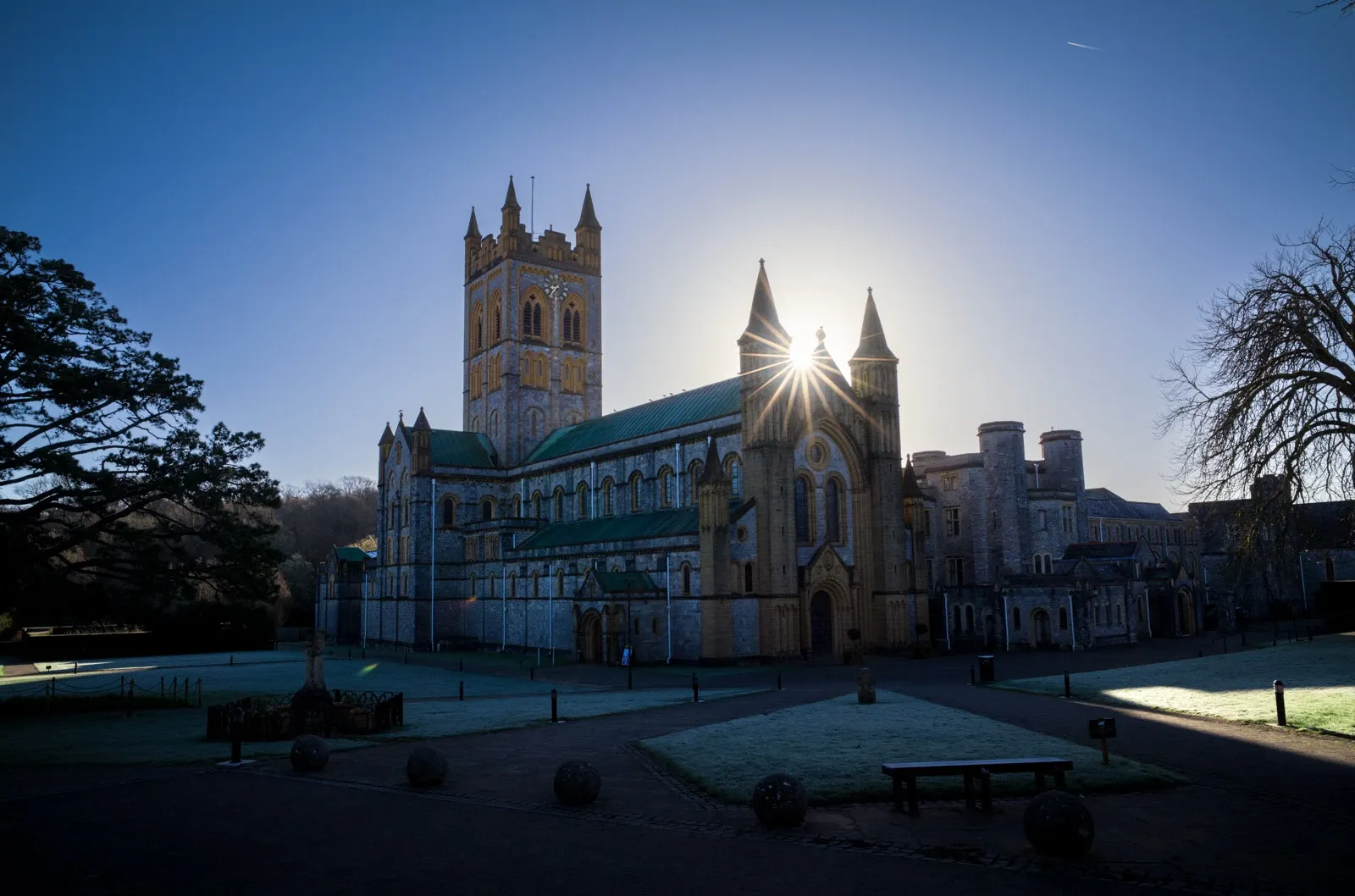 A photograph of Buckfast Abbey during a frosty winter morning with low sun
