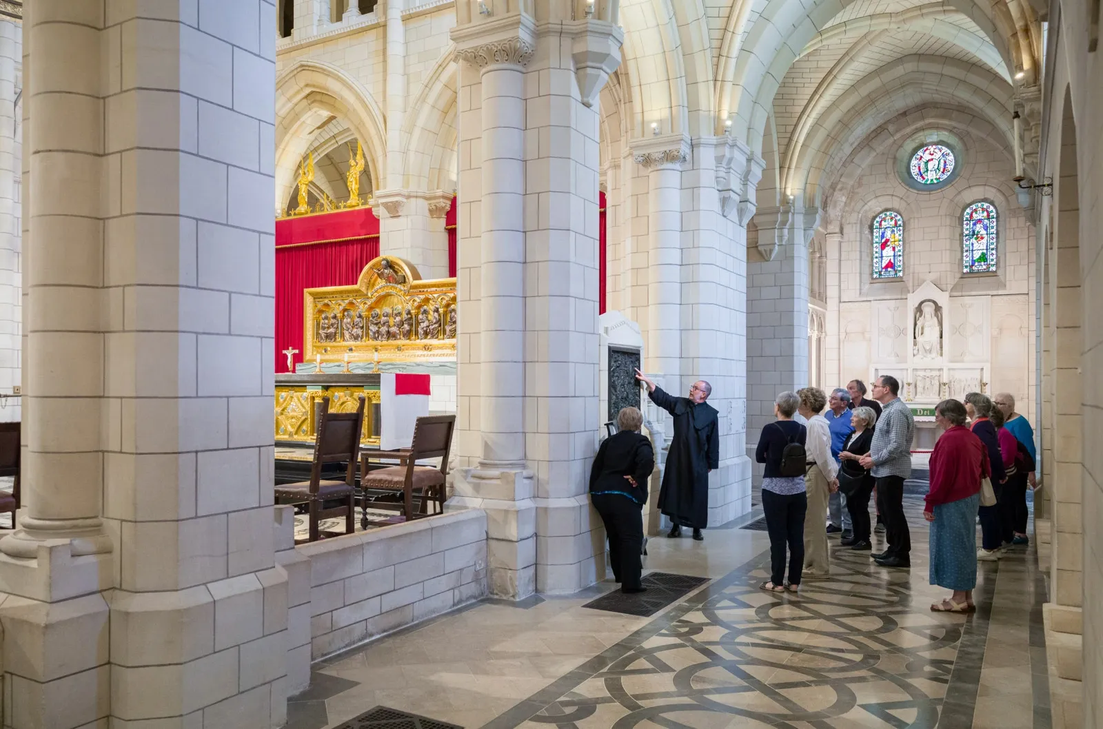 A monk gives a tour to visitors in Buckfast Abbey