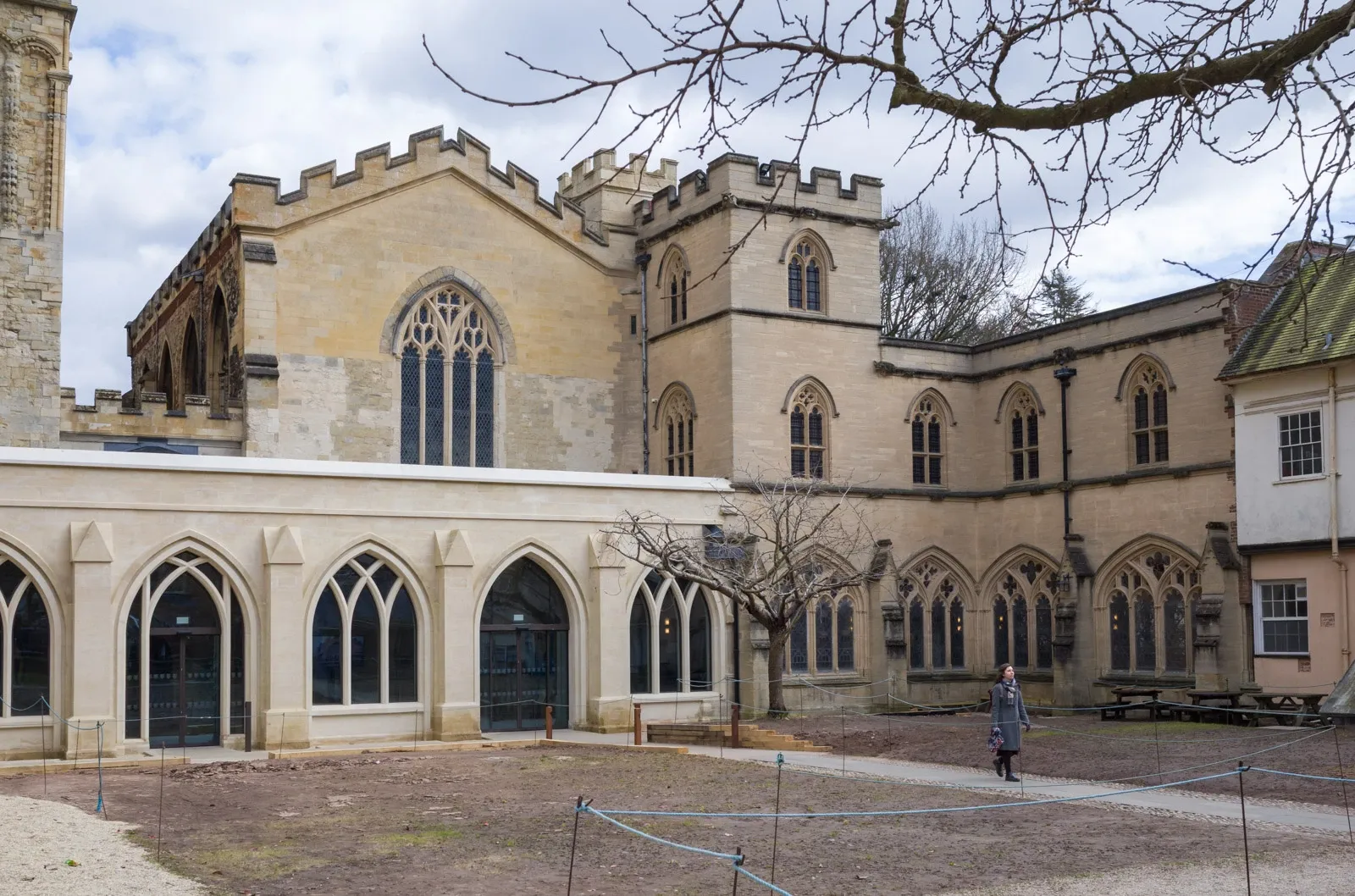 A woman walks through the newly planted garden of Exeter Cathedral's cloister