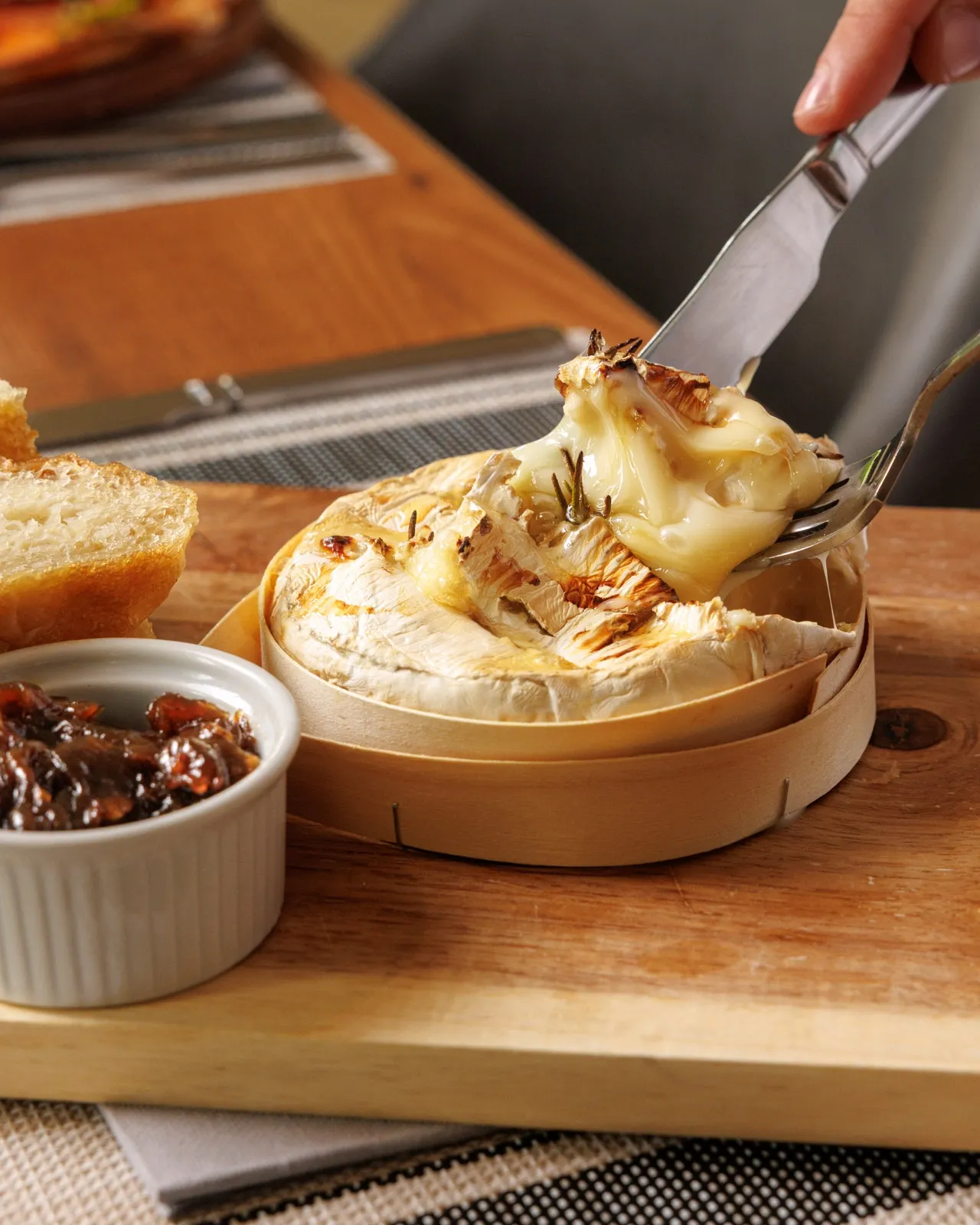 Baked camembert being pulled apart with knife and fork