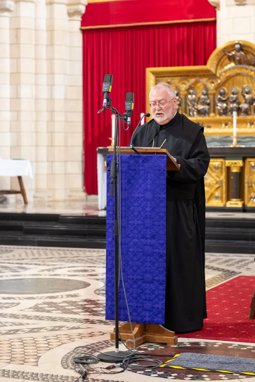 The Abbot of Buckfast Abbey gives a homily into a microphone for the BBC